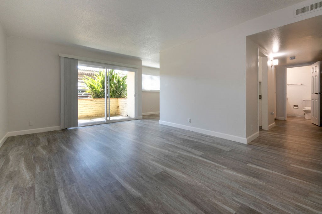 the living room and dining room of an empty house with wood floors