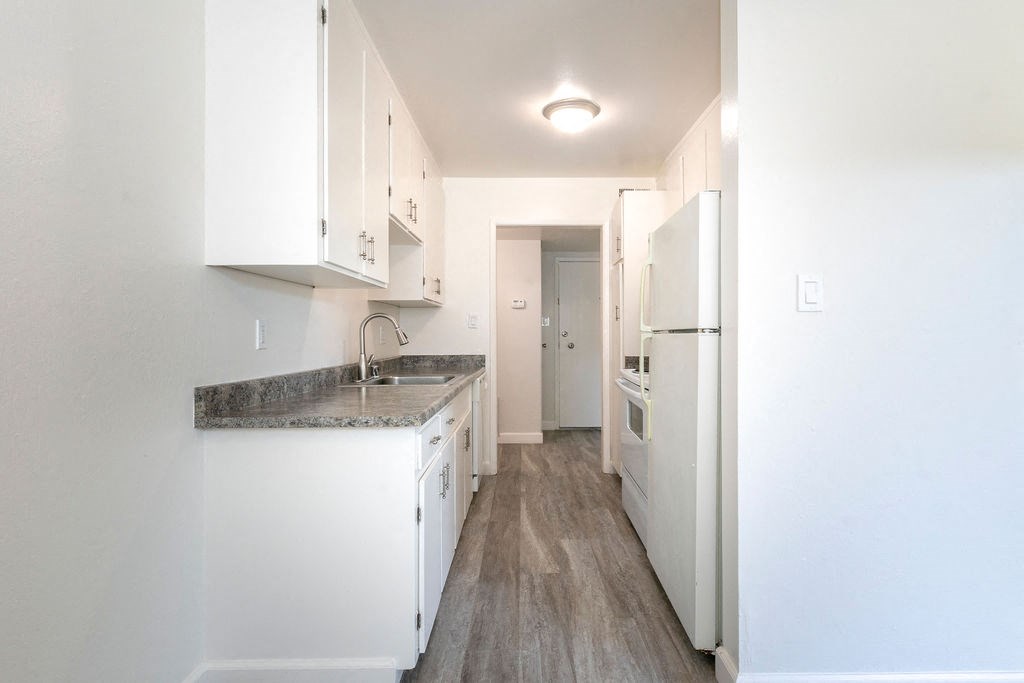 a kitchen with white cabinets and a white refrigerator