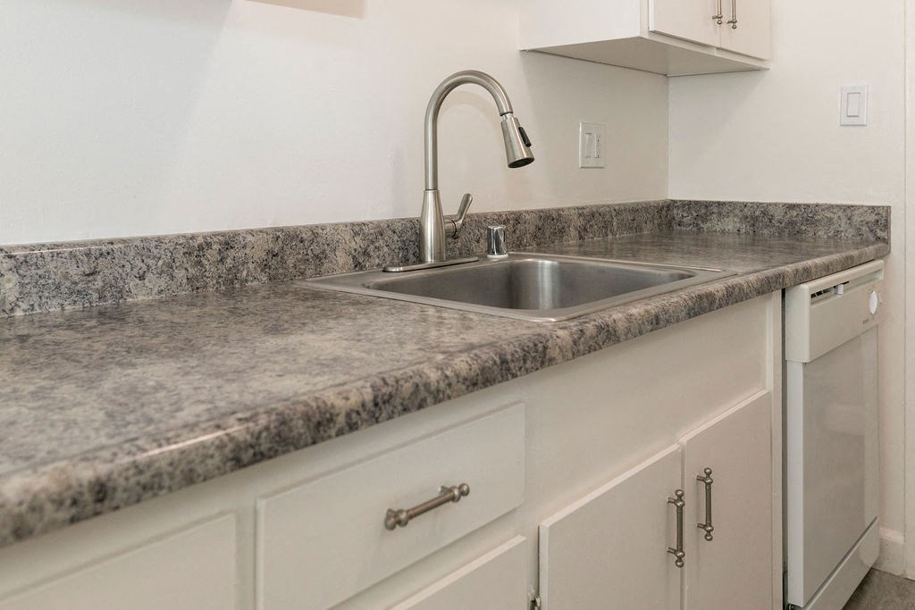 a kitchen with marble counter tops and a sink