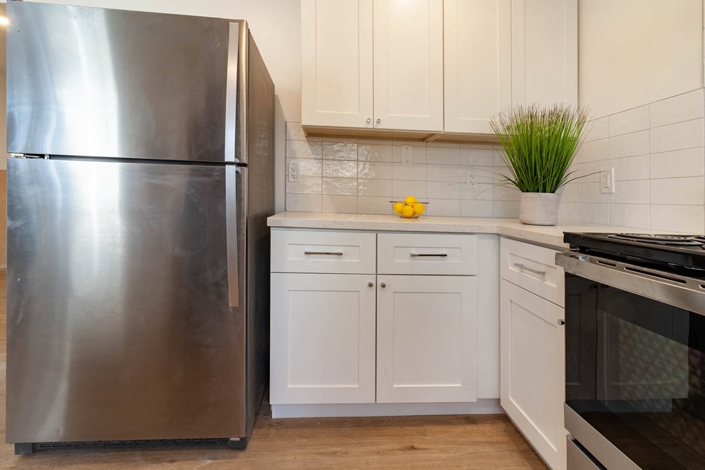 a kitchen with white cabinets and stainless steel appliances