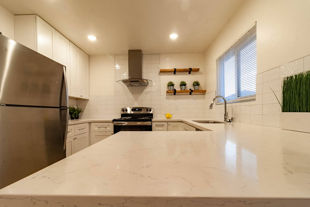 a kitchen with white marble countertops and stainless steel appliances