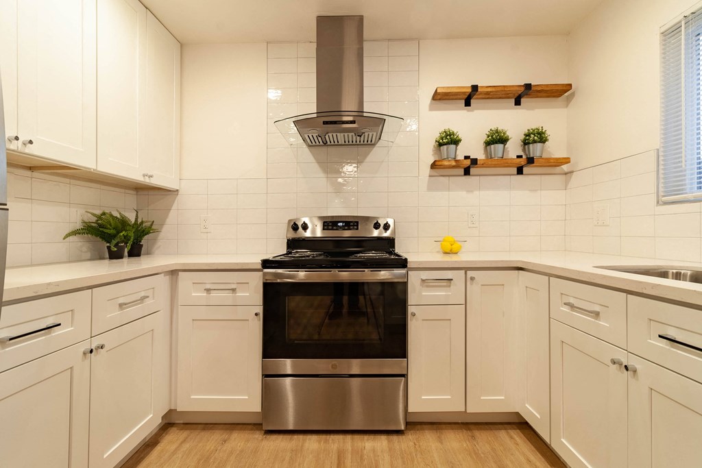 a kitchen with white cabinets and a stainless steel stove