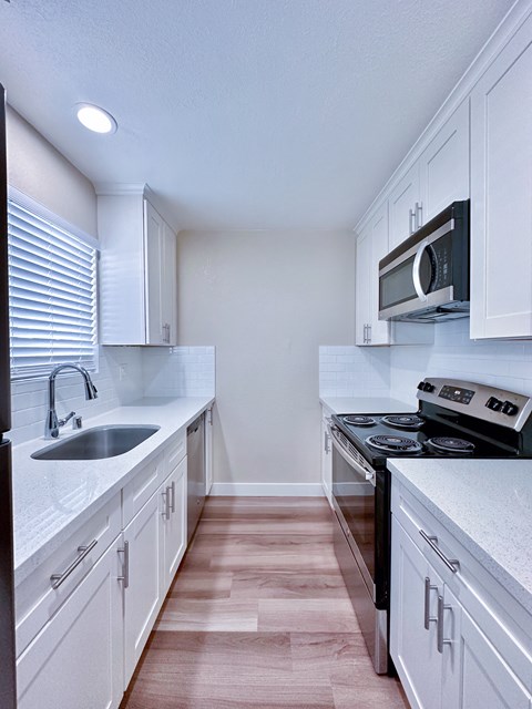 A kitchen with white cabinets and a black stove top oven.