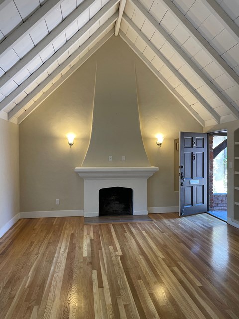 A room with a fireplace and wood flooring.