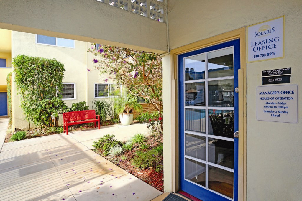 the entrance to the leasing office of a building with a blue door