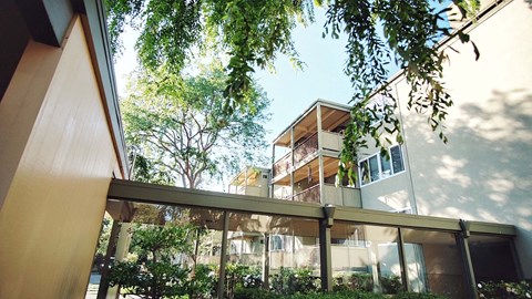 A modern house with a balcony and trees in the background.