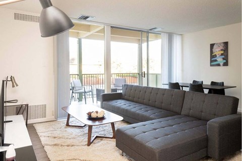 A grey couch sits in a living room with a coffee table in front of it.