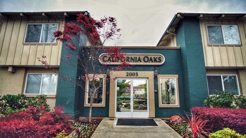 The entrance to a building named California Oaks with a sign that reads 2005.