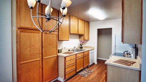 A kitchen with wooden cabinets and a chandelier.