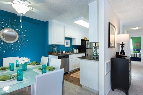 A modern kitchen with a dining table set for two.