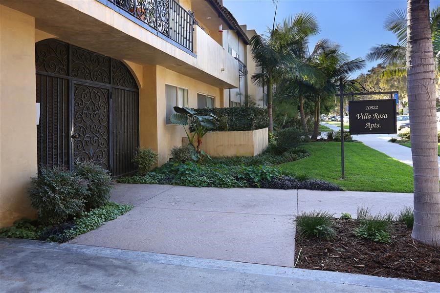 a sidewalk in front of a building with a sign