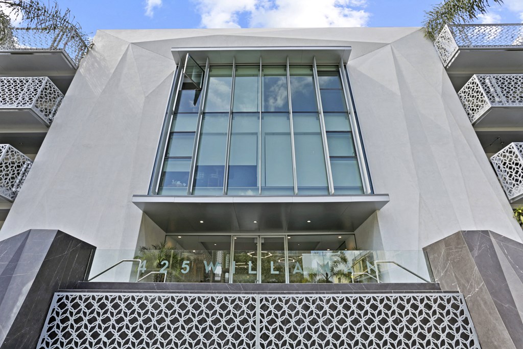 the front of a white building with a glass window and a sign on it