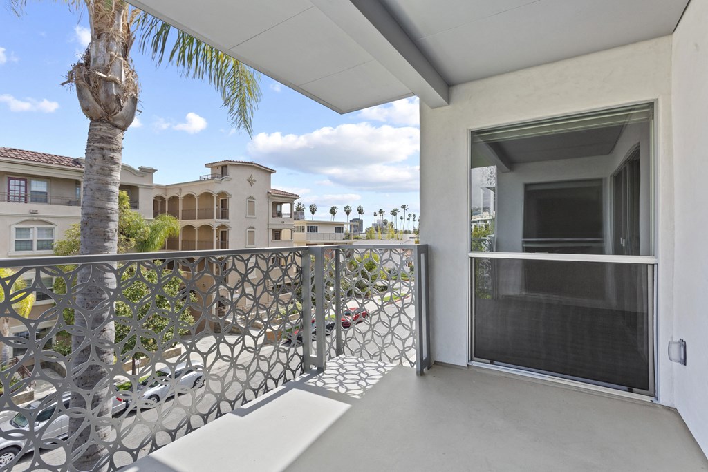 a balcony with a view of the street and a palm tree
