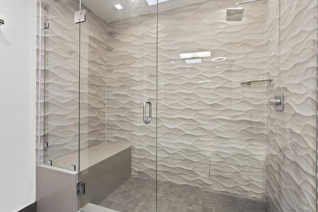 a bathroom with a shower and a wall with wavy tiles