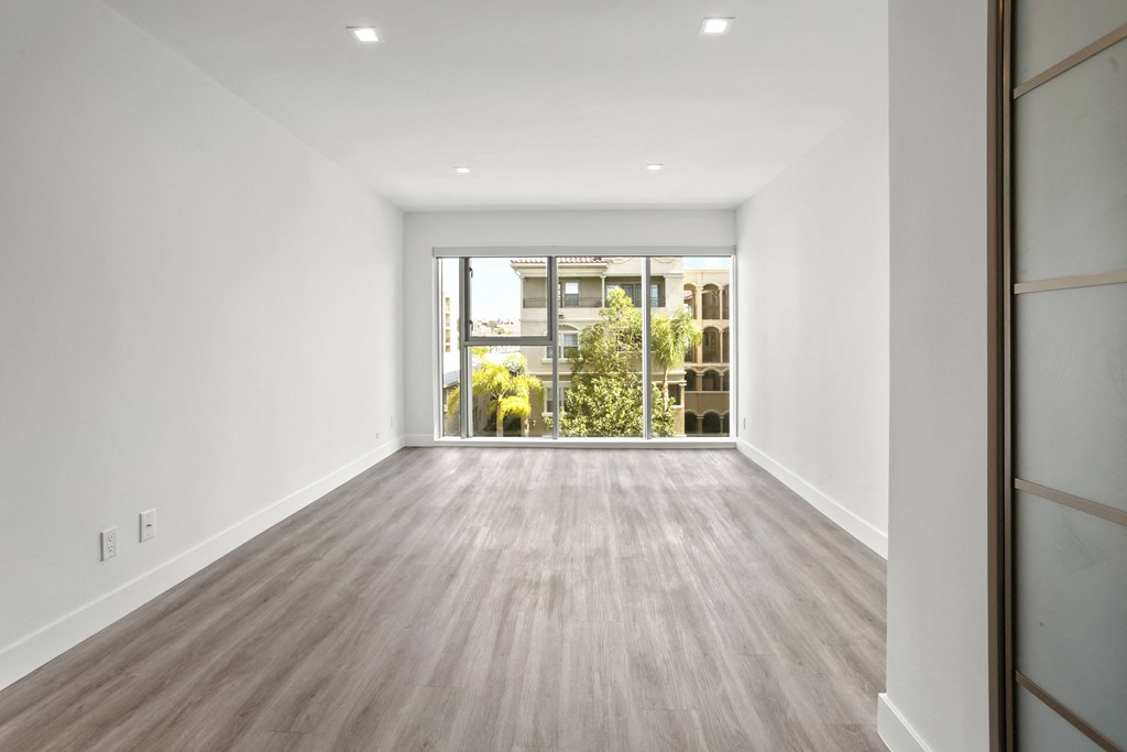 a living room with white walls and a large window