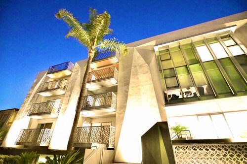 a large building with a palm tree in front of it