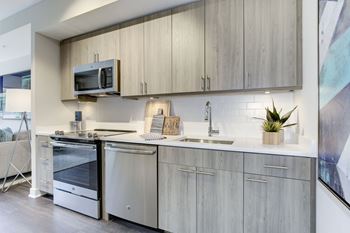 A modern kitchen with a stainless steel oven and microwave above a sink at the Valo Apartments at the Southwest Waterfront in Washington DC 20024