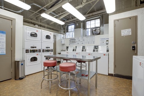 A kitchen area with a table and bar stools.