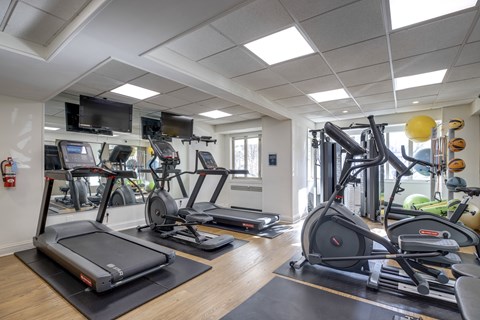 A gym with treadmills, elliptical machines, and other exercise equipment at 2100 Connecticut.