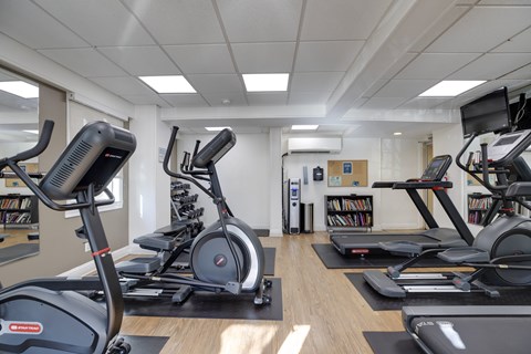 A gym with treadmills and elliptical machines.