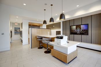 A reception area with a white counter and a television on the wall.