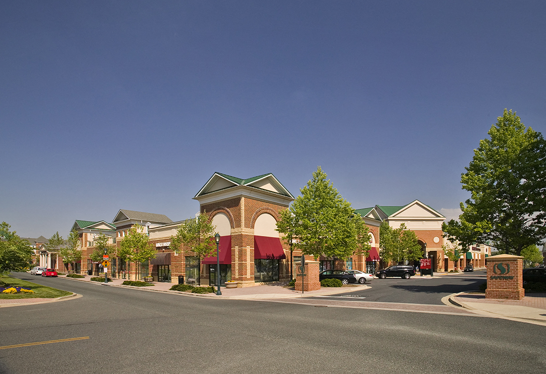 a city street with a building in the foreground and a blue sky in the background