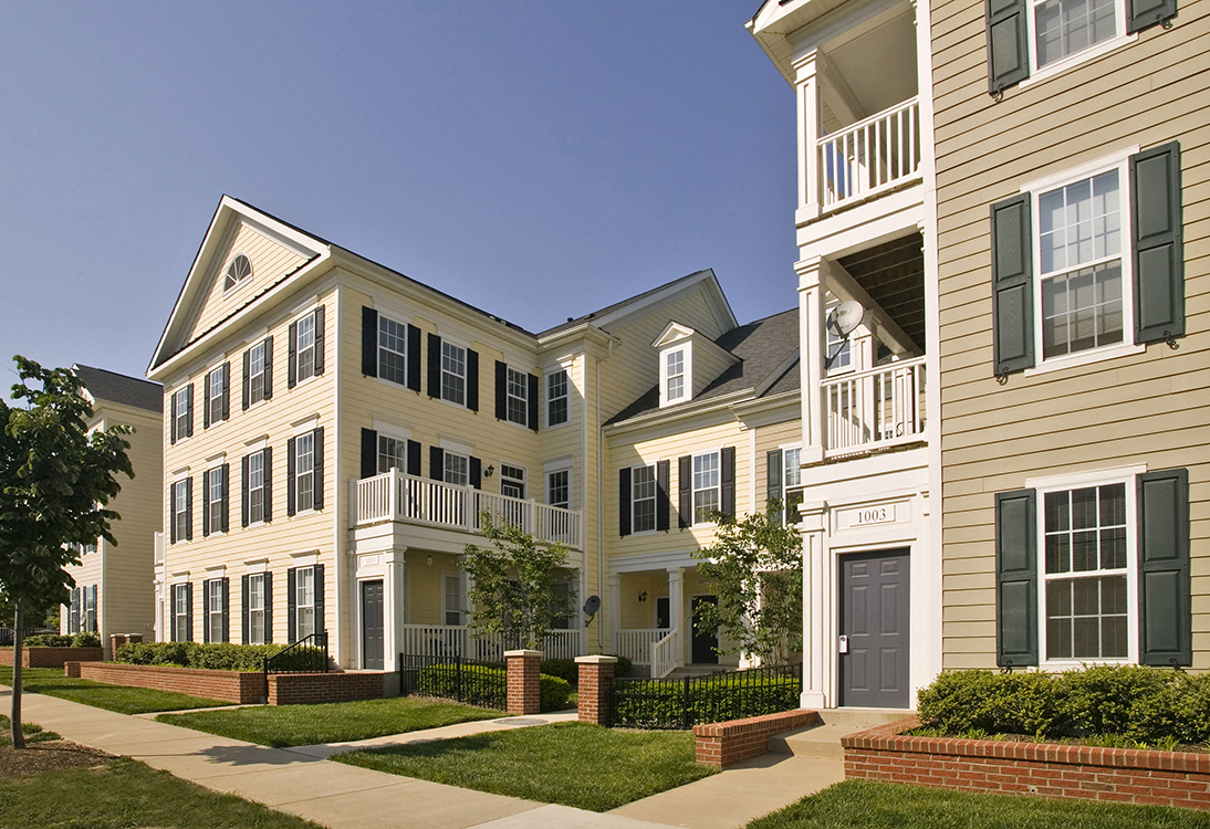 a picture of a row of townhomes with a blue sky in the background