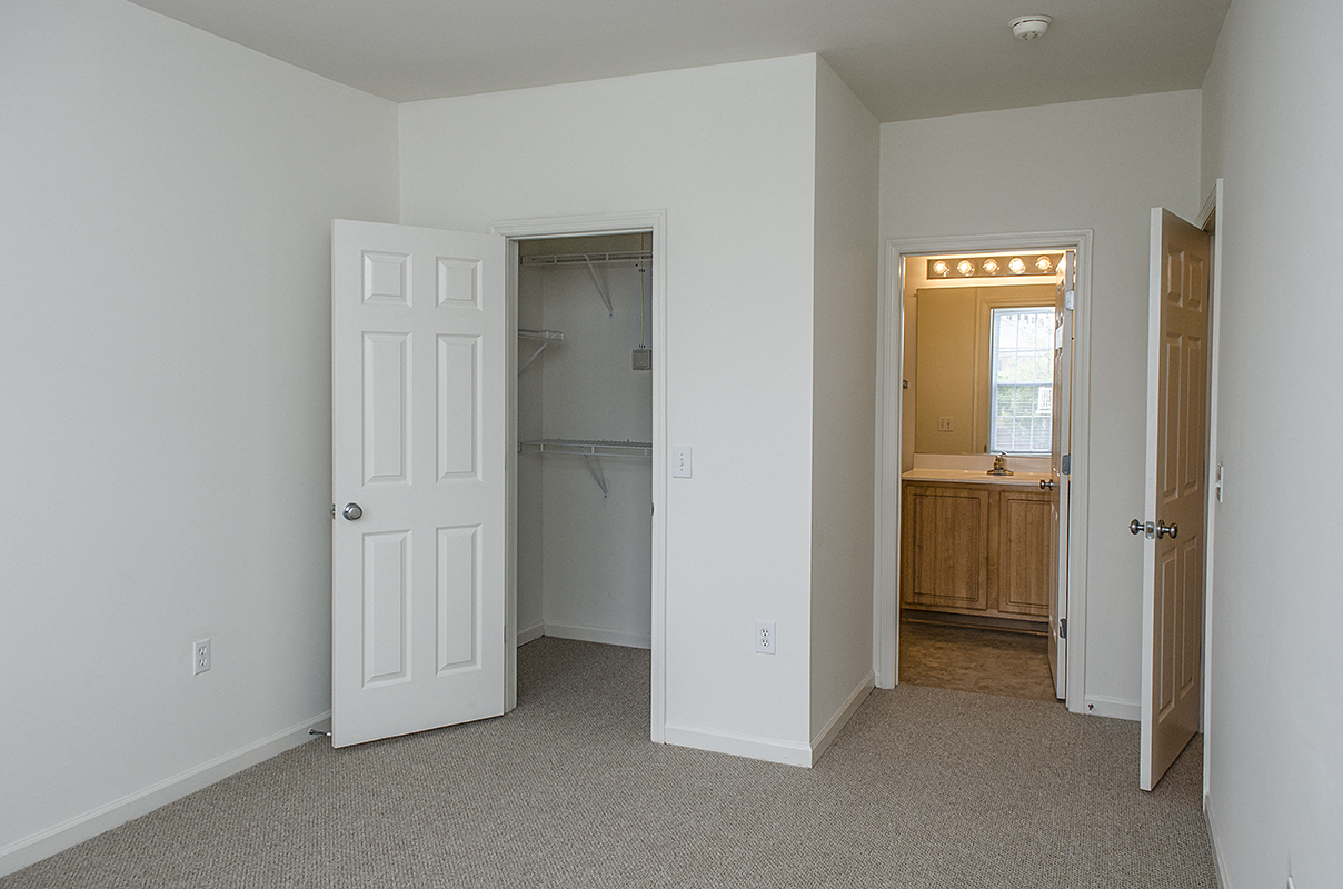 an empty bedroom with a closet and a bathroom