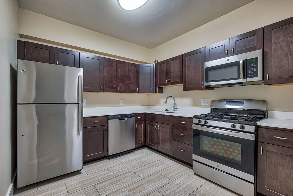 a kitchen with stainless steel appliances and wooden cabinets a kitchen with stainless steel appliances and wooden cabinets at The Argonne Apartments, Washington DC