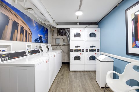 A row of washing machines are lined up in a room.