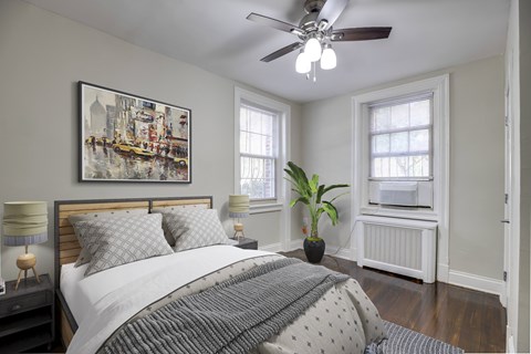 A bedroom with a large bed and a ceiling fan.