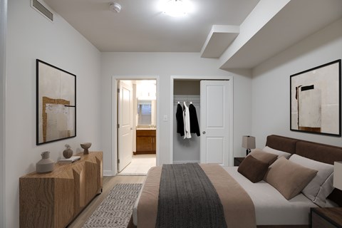 A bedroom with a large bed and a wooden dresser.