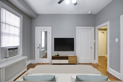 A living room with a white sofa and a black television.