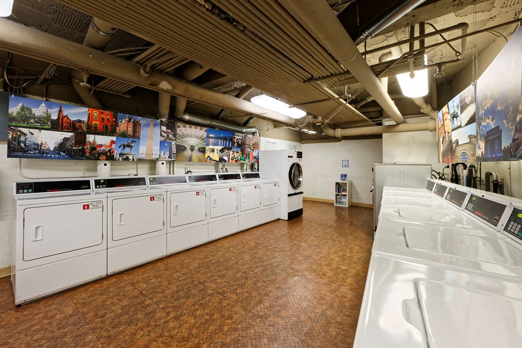 a laundry room with white washers and dryers