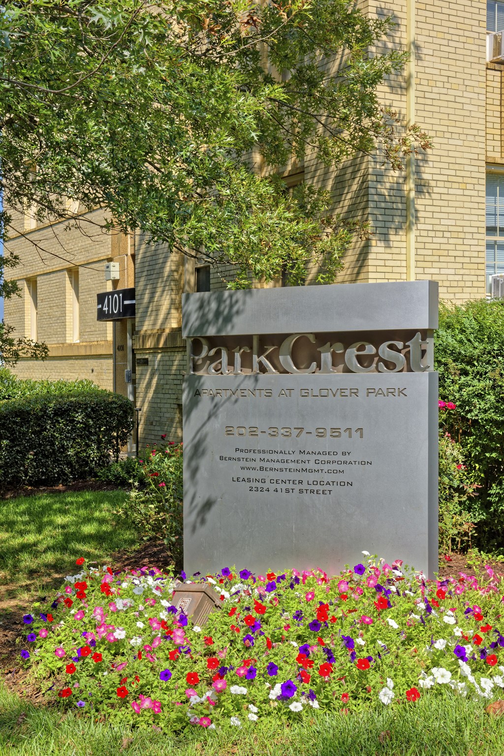 a sign in front of a building with flowers at Park Crest Apartments, Washington, DC
