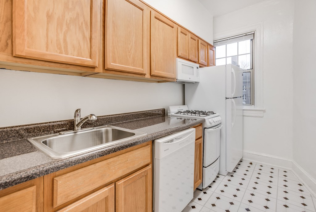 a kitchen with white appliances and wooden cabinets