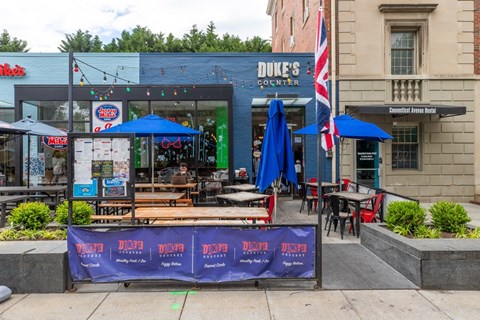 A Duke's corner store with a blue umbrella and a sign that says