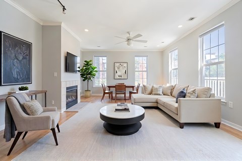A living room with a grey sofa, a grey armchair, a coffee table and a television.