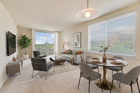 A well-lit living room with a dining table set for four.