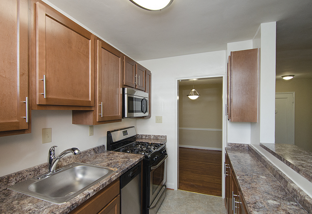 Partially renovated kitchen with stainless steel appliances at Mason Hall in Alexandria, VA 22314