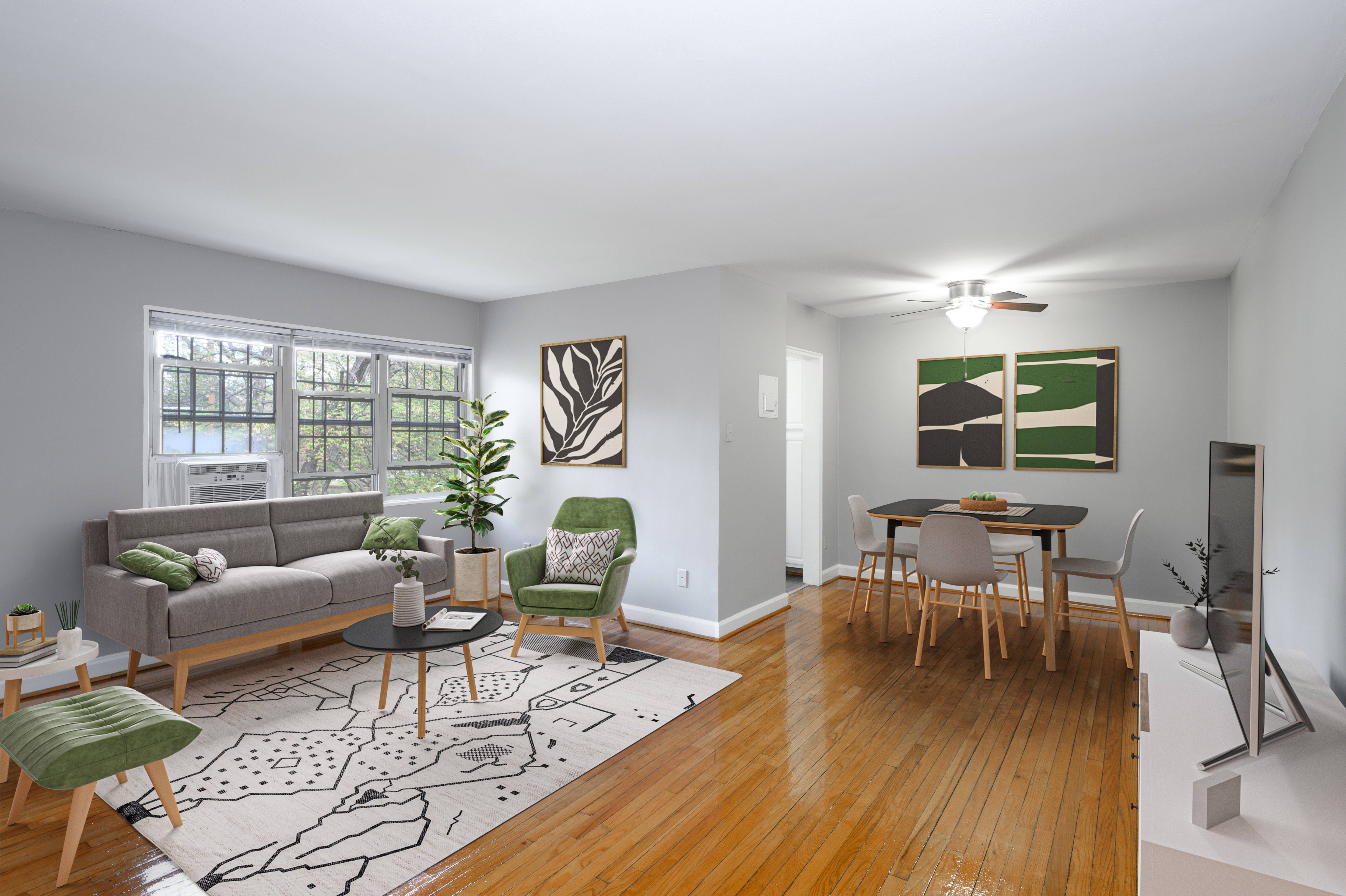 A living room with a grey couch, a green chair, a coffee table, and a dining table with chairs.
