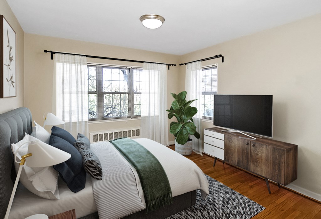 A bedroom with a bed and a tv at Mason Hall in Alexandria, VA 22314