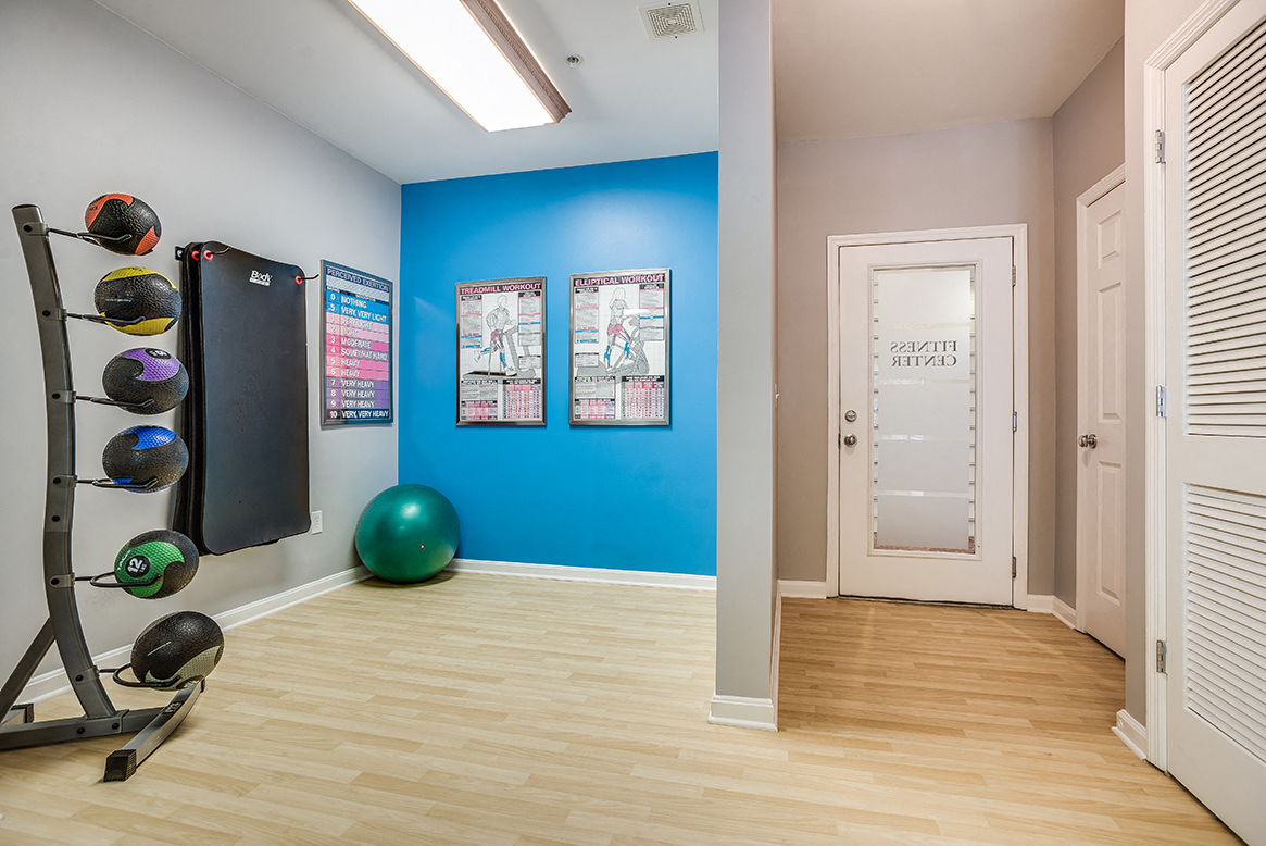a home gym with a blue wall and a treadmill