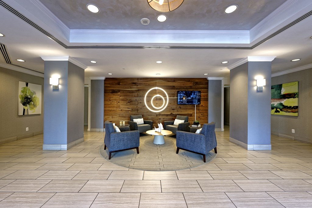 a lobby with couches and chairs and a flat screen tv