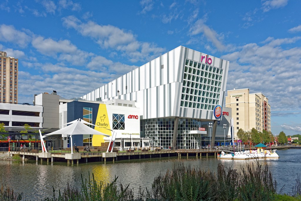 a large white building next to a body of water at Residences at Rio, Gaithersburg, MD