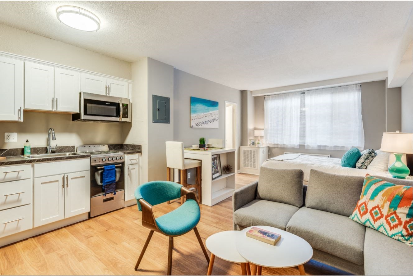 a living room and kitchen with a couch and a table