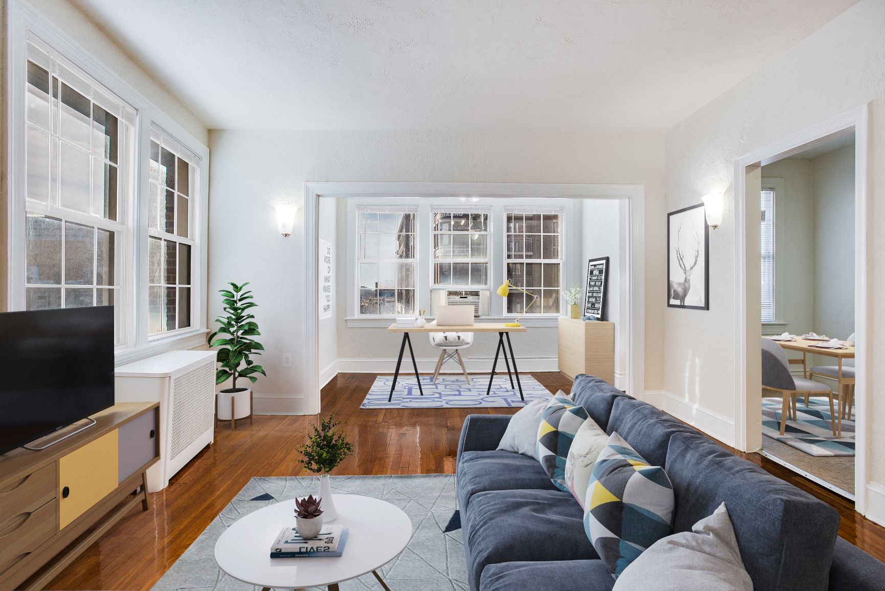 a living room with a blue couch and a white table