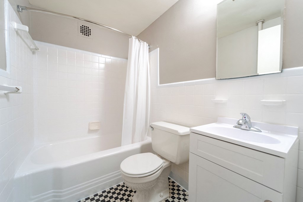 Bathroom with white fixtures and a black and white checkered floors at The York and Potomac Park in Washington DC 20006