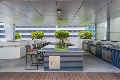 A modern outdoor kitchen with a wooden floor and a bar area.