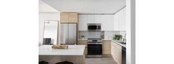 A modern kitchen with a white countertop and a black oven.